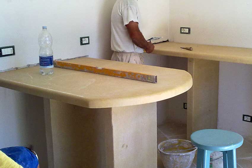 Cucina in muratura moderna con isola in pietra bianca